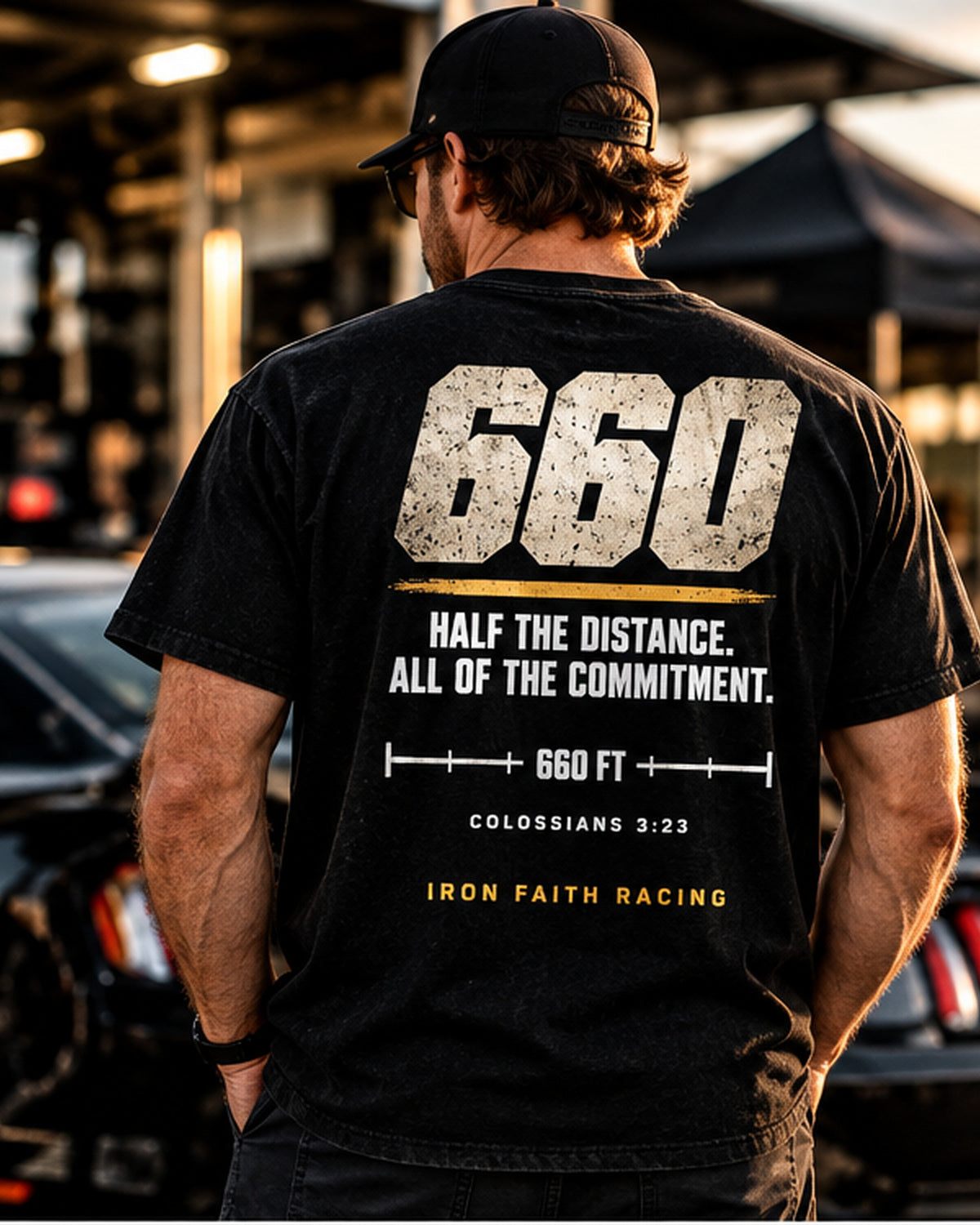 Man in Clean 660 Tee standing beside a car in the pits
