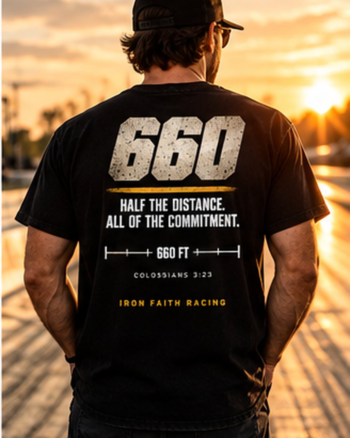 Man in Clean 660 Tee facing the drag strip at sunset