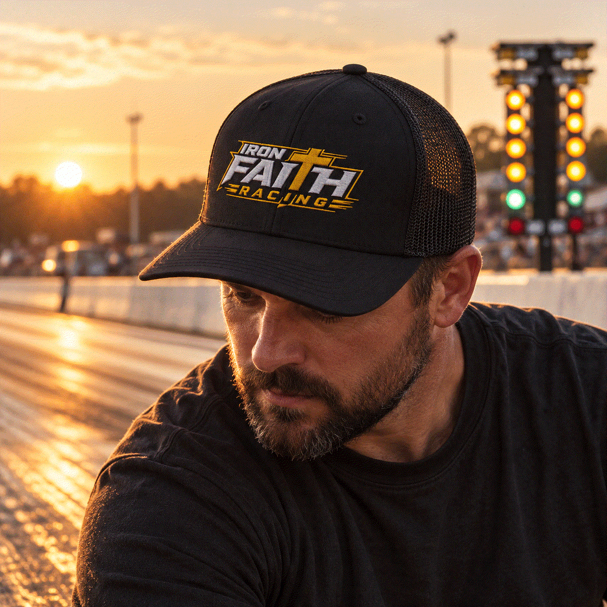 Man in Iron Faith Racing cap working at the drag strip at golden hour
