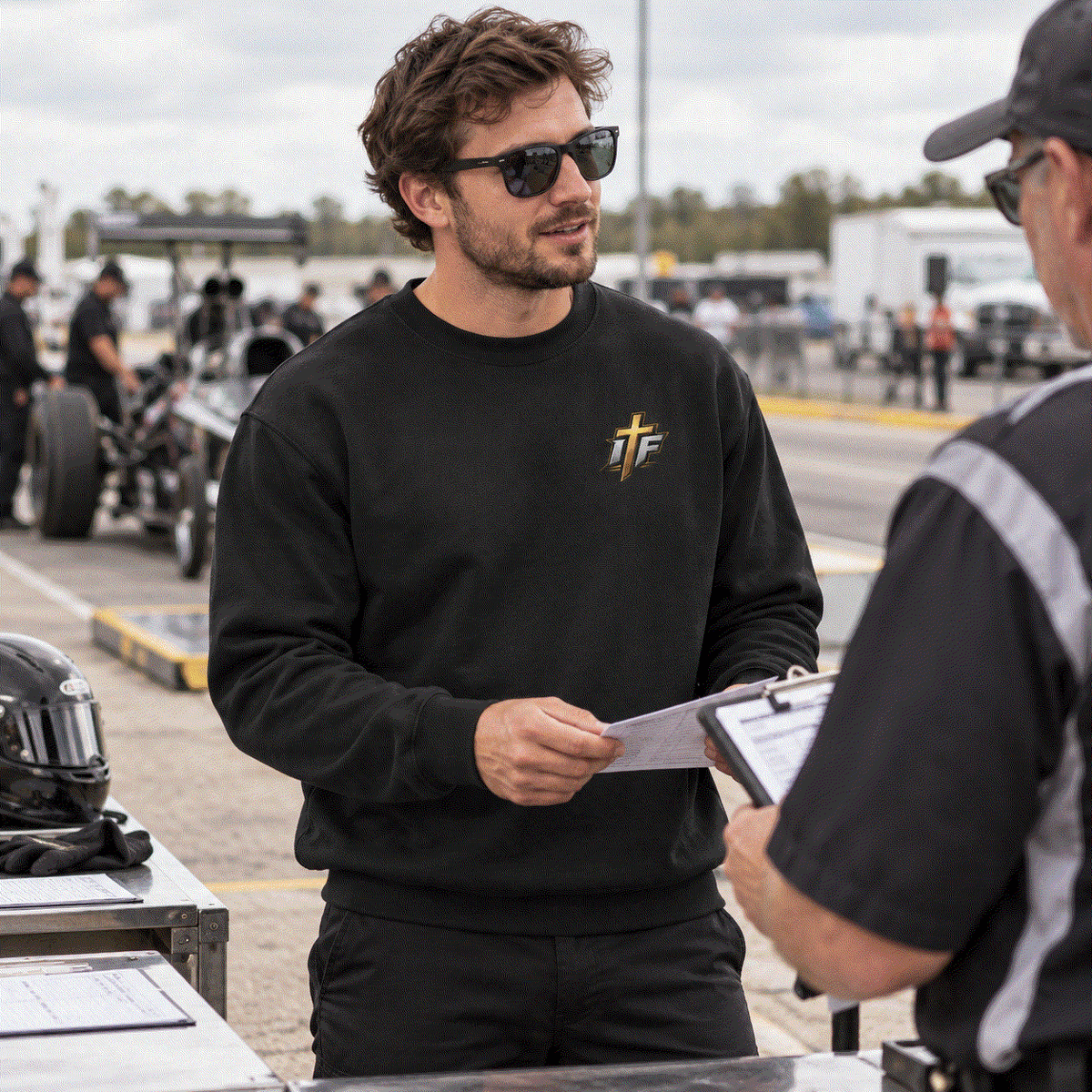 Man in Faith Crewneck going over a clipboard at pre-race tech inspection
