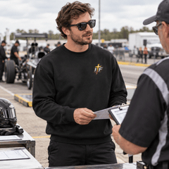 Man in Faith Crewneck going over a clipboard at pre-race tech inspection