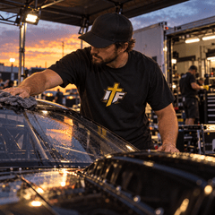 Man in IFR Icon Tee wiping down a drag car in the pit at dusk