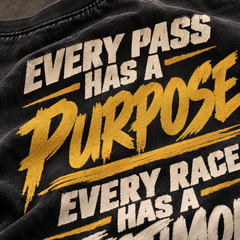 Close-up of gold Every Pass Has a Purpose back print on washed black cotton