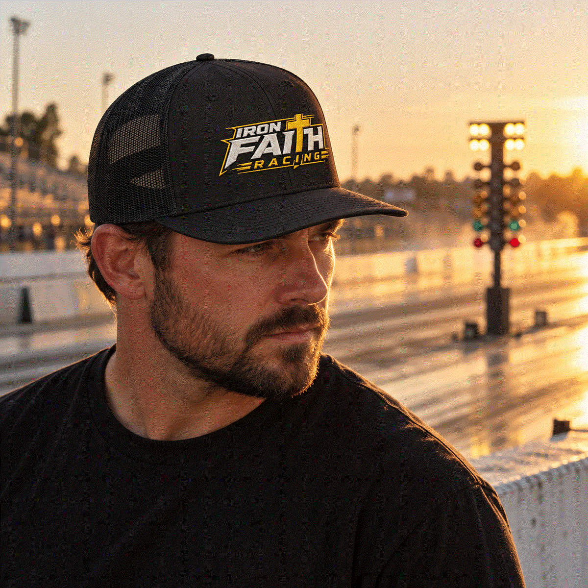 Crew chief in Iron Faith Racing trucker cap at the strip at sunset
