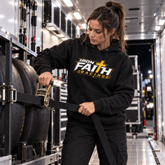 Woman in logo hoodie tightening straps on spare drag slicks in the trailer