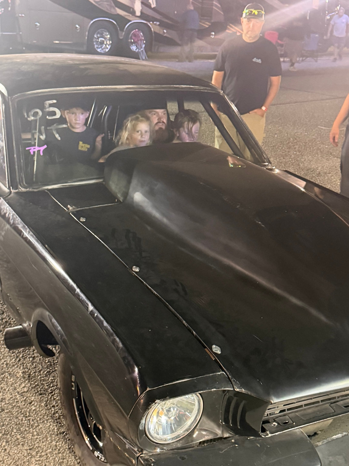 Racers gathered around a car in the pits at Mooresville